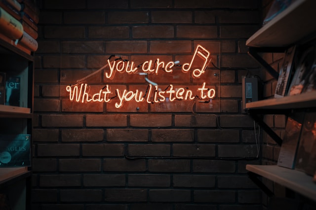 neon sign that says "you are what you listen to"